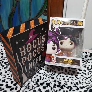 Disney Mary Funko Pop! Figure with Purple and Orange Accents and a wooden decor